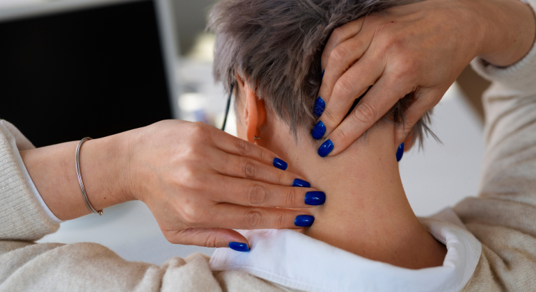 Person massaging the back of their neck with blue-painted nails, focusing on trigger points.