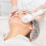 A person receiving a cryotherapy facial, with a handheld device applying cold treatment to the face for skin rejuvenation and tightening.