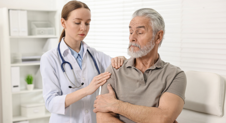 Doctor examining an elderly patient's shoulder pain during a consultation