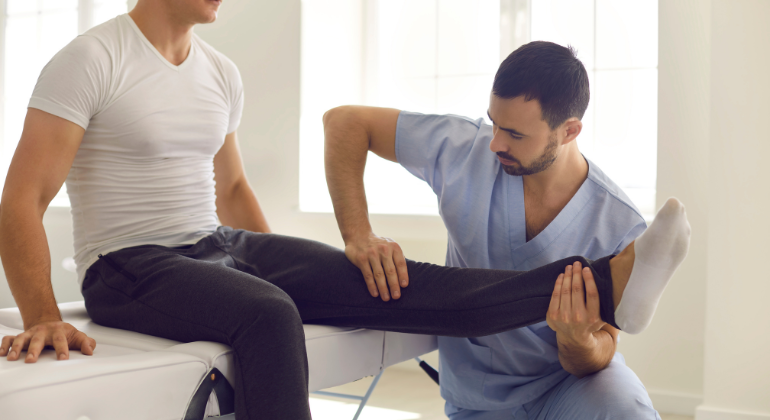 Physiotherapist assessing a patient's knee during a rehabilitation session for joint pain relief