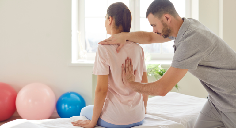 Physiotherapist providing back pain treatment through manual therapy techniques