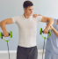 Physiotherapist guiding a male athlete through shoulder rehabilitation exercises using resistance bands during a sports injury recovery session.