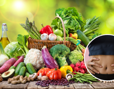 A colorful assortment of fresh vegetables, fruits, and healthy foods on a wooden table, symbolizing a nutritious diet for recovery. Inset shows a person holding their abdomen, indicating the importance of diet in supporting navel displacement recovery.