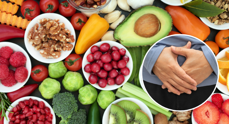 A variety of healthy, nutrient-rich foods such as fruits, vegetables, nuts, and seeds alongside an image of a person holding their abdomen, symbolizing the role of diet in navel displacement recovery.