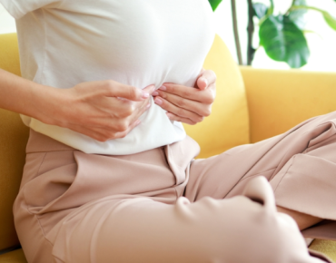 Female patient receiving abdominal massage for navel displacement, a condition that can indirectly affect reproductive health.