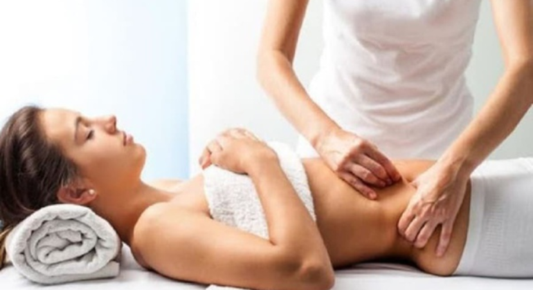 A therapist performing abdominal massage on a woman lying on a treatment table. The image highlights a therapeutic approach to address abdominal issues such as navel displacement or muscle tension.